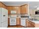 Well-lit kitchen featuring wooden cabinetry, modern appliances, and a stylish backsplash at 2524 Forest Shadows Ln, Raleigh, NC 27614