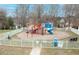Community playground with slides, swings, and climbing structures fenced in at 2524 Forest Shadows Ln, Raleigh, NC 27614