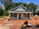 Charming single-story home with gray siding, wood columns, and a cozy front porch under a bright blue sky at 274 Longbow Dr, Middlesex, NC 27557