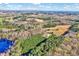 Aerial view of land featuring a mix of grassy areas, dense trees, and a tranquil pond at 290 Collie Rd, Castalia, NC 27816