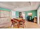 Bright dining room featuring laminate flooring, a farmhouse table, and cabinets for storage at 290 Collie Rd, Castalia, NC 27816