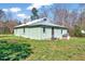 Single-story home featuring light green siding, a brick chimney, and a metal roof at 290 Collie Rd, Castalia, NC 27816
