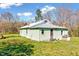 A single-story home has light green siding, a brick chimney, and a metal roof at 290 Collie Rd, Castalia, NC 27816