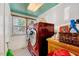 Functional laundry room with red washer/dryer and ample cabinet space, plus a large window at 290 Collie Rd, Castalia, NC 27816