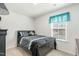 Cozy bedroom with a dark bed frame and stylish bedding, plus natural light from the window at 2902 Cullens Dr, Graham, NC 27253