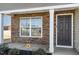 Close up of front porch with stone accents, black door, and manicured landscaping at 2902 Cullens Dr, Graham, NC 27253