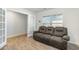 Living room showcases a comfortable brown reclining sofa, wood flooring, and a view of the front window at 2902 Cullens Dr, Graham, NC 27253