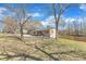 Side angle of home showing the yard, gravel driveway, and wooden fence on a sunny day at 2914 Old Stage N Rd, Coats, NC 27521