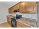 Kitchen with laminate countertops, wood cabinets, and black appliances at 2914 Old Stage N Rd, Coats, NC 27521
