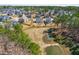 Scenic aerial view showcasing backyard pond, tree coverage, and a desirable neighborhood community at 3574 Johnson Grant Dr, New Hill, NC 27562