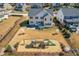 An aerial view of the house showing the back yard with a swing set and slide, surrounded by neighboring houses at 3574 Johnson Grant Dr, New Hill, NC 27562