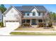 Traditional two-story home with a teal front door, well-maintained lawn, and attached two-car garage at 3574 Johnson Grant Dr, New Hill, NC 27562