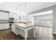 Open concept kitchen with island, granite countertops, white cabinetry and stainless steel appliances at 3574 Johnson Grant Dr, New Hill, NC 27562