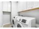 Functional laundry room with upper cabinets, a washer, and a dryer at 3574 Johnson Grant Dr, New Hill, NC 27562