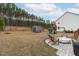 Expansive backyard with storage shed, play set, firepit, and wooded backdrop at 3727 Horton Hill Dr, New Hill, NC 27562