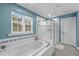 Bright bathroom features a soaking tub with window view and a glass-enclosed shower at 3727 Horton Hill Dr, New Hill, NC 27562