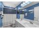Blue bathroom with double vanity and tiled shower-tub with anchor curtain at 3727 Horton Hill Dr, New Hill, NC 27562