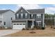 Beautiful two-story home showcasing gray siding, black shutters and well manicured front lawn at 3727 Horton Hill Dr, New Hill, NC 27562