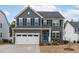 Charming two-story home featuring gray siding, black shutters, and a bright blue front door at 3727 Horton Hill Dr, New Hill, NC 27562