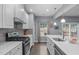 Modern kitchen boasts stainless steel appliances, gray backsplash, and large window for natural light at 3727 Horton Hill Dr, New Hill, NC 27562