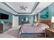 Bright main bedroom features a tray ceiling, carpeted floors, a ceiling fan, and a view of the backyard at 3727 Horton Hill Dr, New Hill, NC 27562