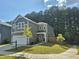 Inviting two-story home with attached garage, lush green lawn, and a charming, covered front porch at 4000 Passenger Pl, Durham, NC 27703