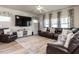 Inviting living room with a plush leather sectional, large TV, and ample natural light at 4000 Passenger Pl, Durham, NC 27703