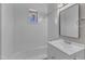 A bright bathroom with white herringbone tiling, bathtub, and a window view to the outside at 417 Baker St, Nashville, NC 27856