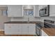 Close-up of the kitchen with a modern range, sink, subway tile, and butcher block countertops at 417 Baker St, Nashville, NC 27856
