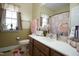 Well-lit bathroom with a strawberry accent rug, pink daisy shower curtain, and window at 4336 N Greg Allen Way, Oxford, NC 27565