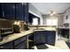 A stylish kitchen featuring blue cabinets, marble countertops, and stainless steel appliances at 4336 N Greg Allen Way, Oxford, NC 27565