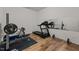 Basement gym with wood floors, weight-lifting equipment, treadmill, and mirrored wall at 505 Marion Hills Way, Knightdale, NC 27545