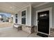 Covered front porch featuring a bench and a black front door with glass panes at 505 Marion Hills Way, Knightdale, NC 27545