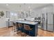 Modern kitchen island featuring a white countertop, navy blue cabinetry, and bar stools at 505 Marion Hills Way, Knightdale, NC 27545