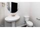 Charming powder room featuring a pedestal sink, toilet, and round mirror at 518 Parlier Dr # 82, Apex, NC 27523