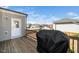 View of a wooden deck with grill, gray vinyl siding, and white door under a cloudy blue sky at 518 Parlier Dr # 82, Apex, NC 27523