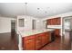 Kitchen with wooden cabinets, hardwood floors, granite island, stainless steel dishwasher, and modern pendant lighting at 518 Parlier Dr # 82, Apex, NC 27523