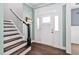 Bright entryway with a white front door, decorative molding, and hardwood floors leading to a staircase at 52 Reserve Dr, Fuquay Varina, NC 27526