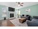 Comfortable living room with a fireplace, TV, large windows, hardwood floors, and stylish decor at 52 Reserve Dr, Fuquay Varina, NC 27526