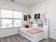 Bright bedroom with built-in shelves, a cozy bed, and a view of the neighborhood through the window at 521 Ivy Arbor Way, Holly Springs, NC 27540