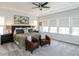 Serene main bedroom with neutral color palette, large windows, and comfortable seating area at 521 Ivy Arbor Way, Holly Springs, NC 27540