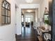 Elegant entryway with dark hardwood floors, a decorative mirror, and views into the living spaces at 521 Ivy Arbor Way, Holly Springs, NC 27540
