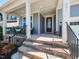 Inviting front porch featuring stone steps, black metal railings, and ample space for seating at 521 Ivy Arbor Way, Holly Springs, NC 27540
