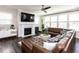 Cozy Gathering room with a fireplace, a large leather sectional, and many windows at 521 Ivy Arbor Way, Holly Springs, NC 27540