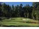 Scenic golf course view featuring lush green fairways, sand traps, and mature trees at 521 Ivy Arbor Way, Holly Springs, NC 27540