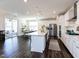Bright, spacious kitchen with white cabinets, stainless steel appliances, large island, and adjacent dining area at 521 Ivy Arbor Way, Holly Springs, NC 27540