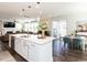Open kitchen with an island and stainless steel appliances, flowing into the dining area and living space at 521 Ivy Arbor Way, Holly Springs, NC 27540