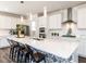 Modern kitchen with white cabinetry, a large center island, stainless steel appliances, and designer backsplash at 521 Ivy Arbor Way, Holly Springs, NC 27540