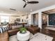 Open-concept living room featuring a leather sofa, white ottoman, and seamless flow into the adjacent modern kitchen at 521 Ivy Arbor Way, Holly Springs, NC 27540