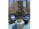 Inviting outdoor fireplace with stone surround, plush chairs, and stylish table, perfect for relaxing evenings at 521 Ivy Arbor Way, Holly Springs, NC 27540